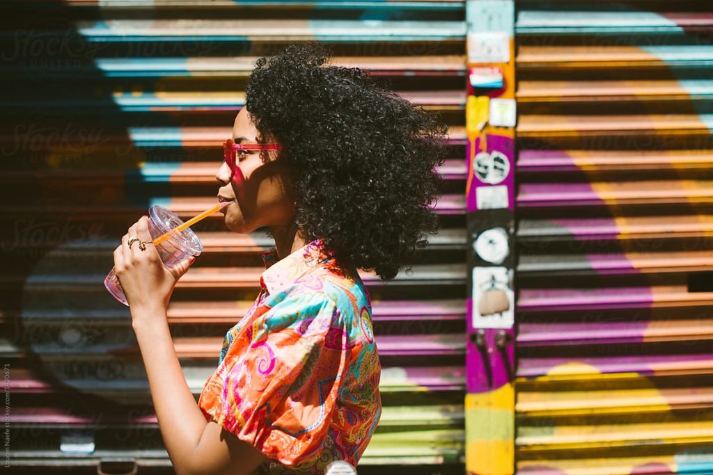 African-American Woman with Colorful Shirt drinking from a straw